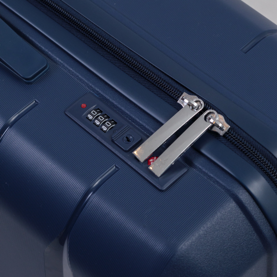 Candado TSA de combinacion en una valija azul, con cremalleras insertadas y numeros visibles.